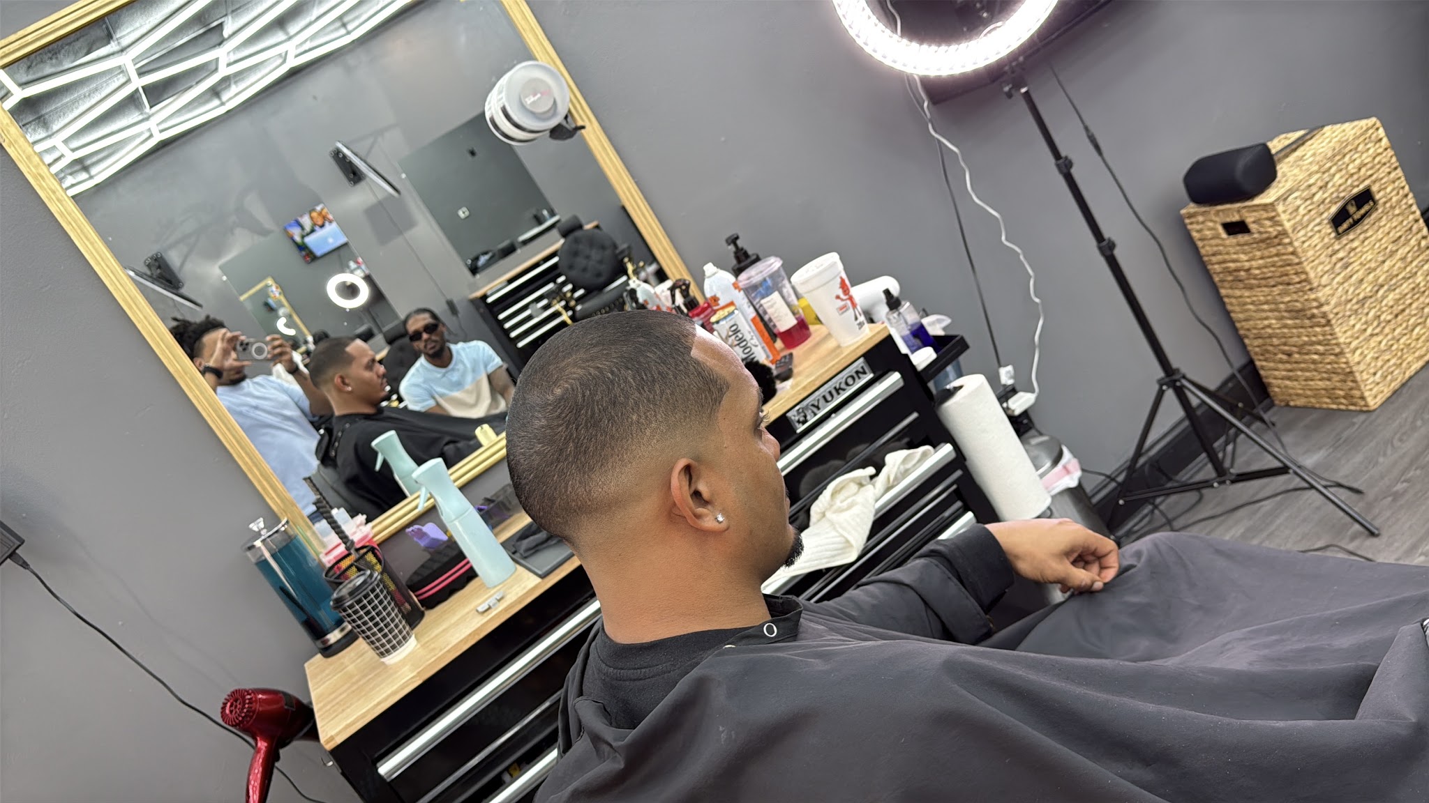 A client in the chair getting a clean skin fade at Alta Gama Barbershop